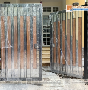 Cổng gỗ nhựa kết hợp nan gỗ nhựa composite và khung thép hộp sơn đen.